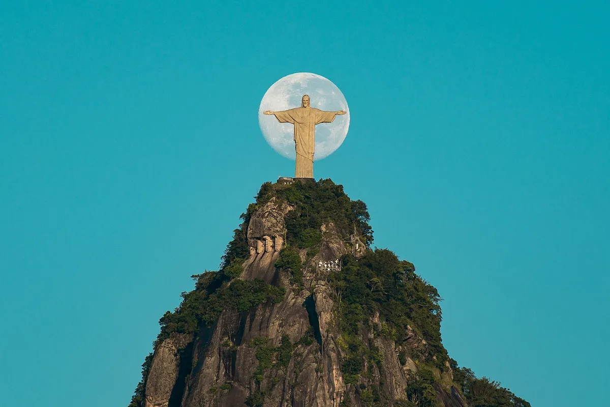 The Christ the Redeemer statue with arms outstretched above Rio de Janeiro and Guanabara Bay