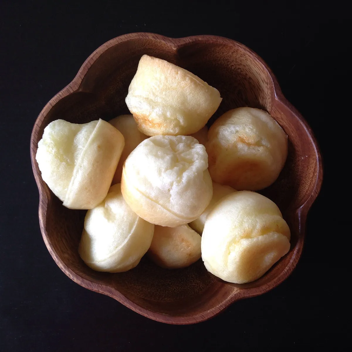 A linen-lined basket of golden, puffed pão de queijo still warm from the oven