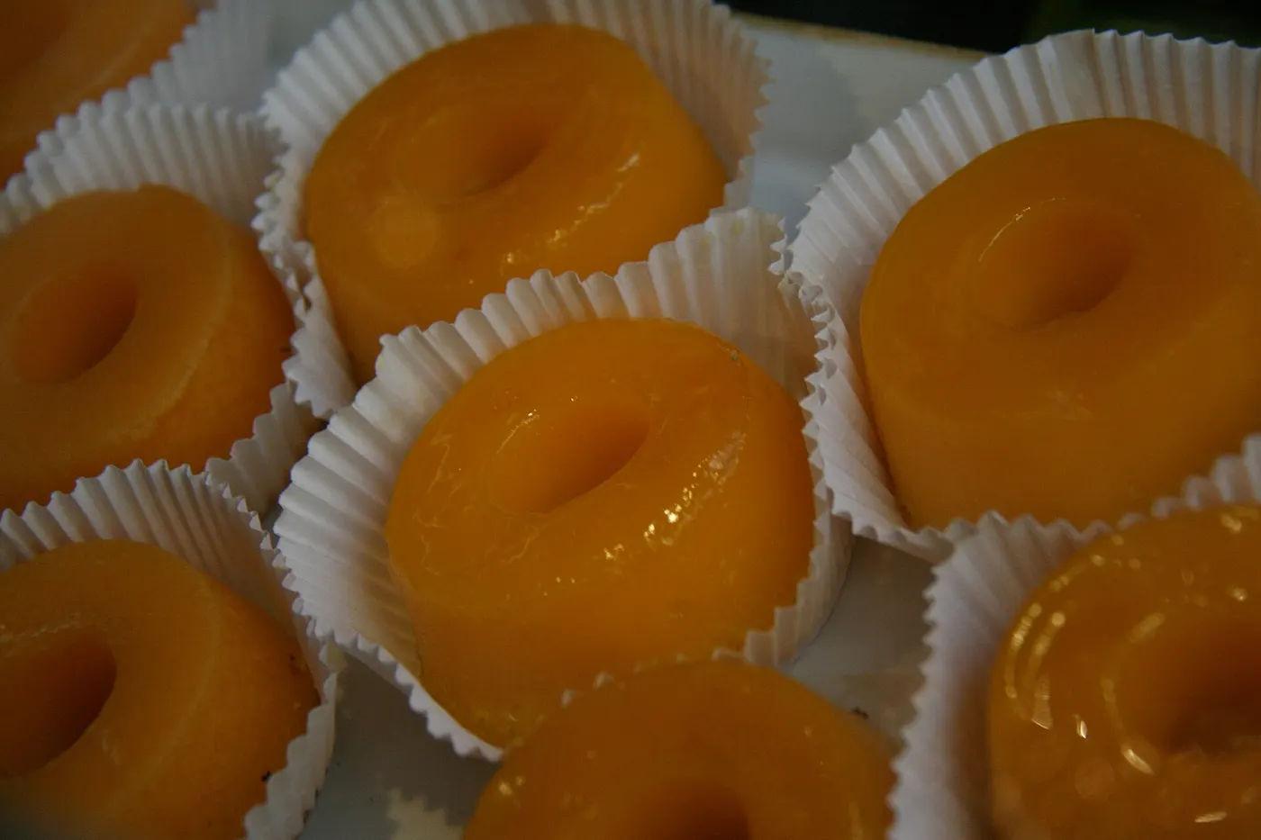 A bright-yellow quindim beside white coconut beijinho sweets