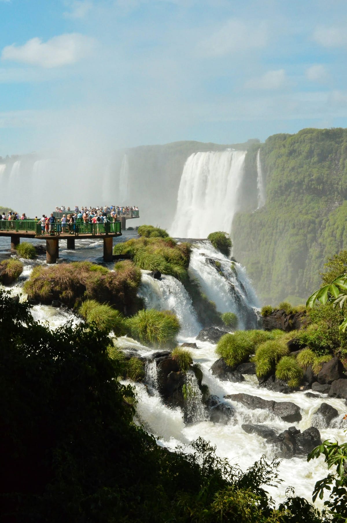 Iguaçu Falls cascading beside a rainforest walkway