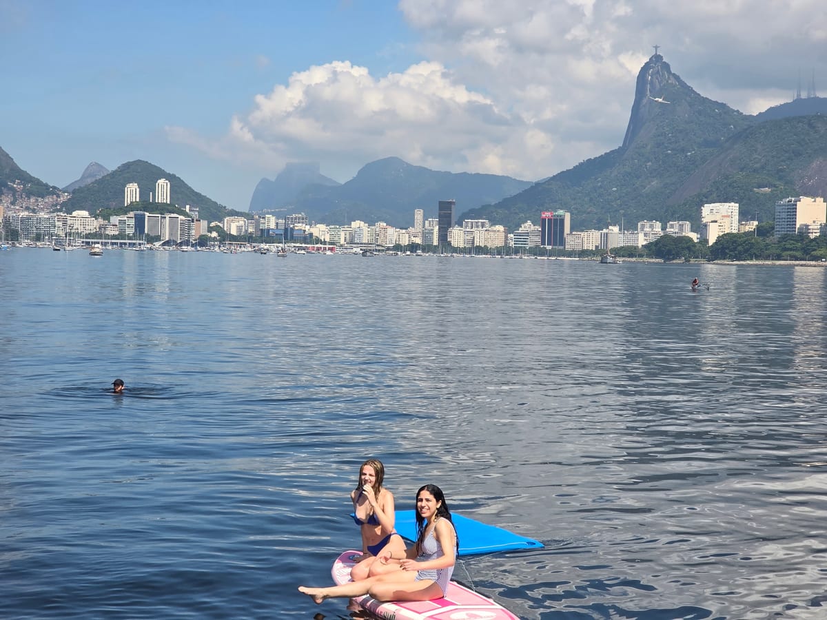 A traveller floating on the calm bay with the Rio de Janeiro skyline behind