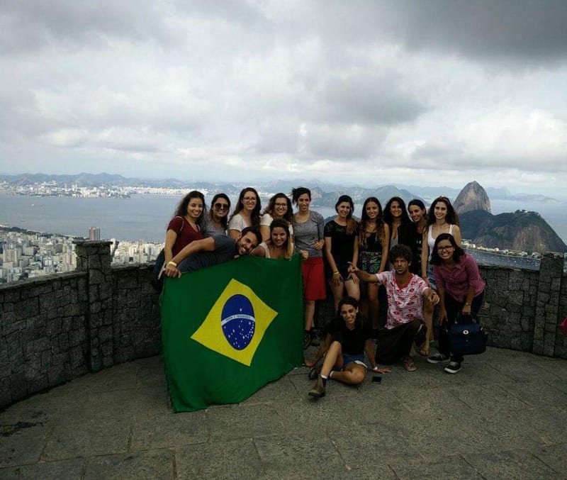 A tour group holding a Brazilian flag at a Rio de Janeiro viewpoint
