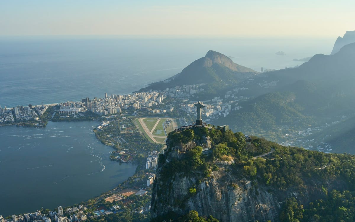 Christ the Redeemer atop Corcovado with Sugarloaf Mountain and Guanabara Bay behind in Rio de Janeiro